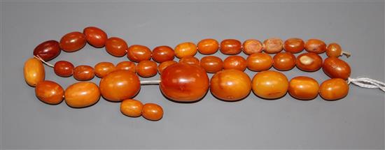 A single strand graduated oval amber bead necklace, gross 49 grams (a.f.).